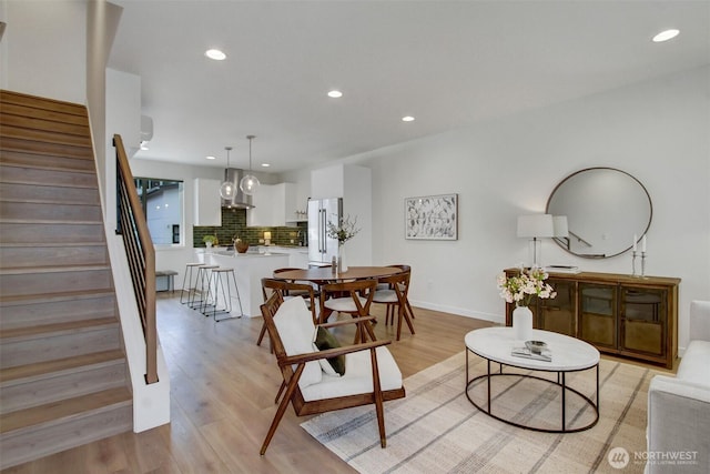 living room featuring recessed lighting, stairway, light wood-style flooring, and baseboards