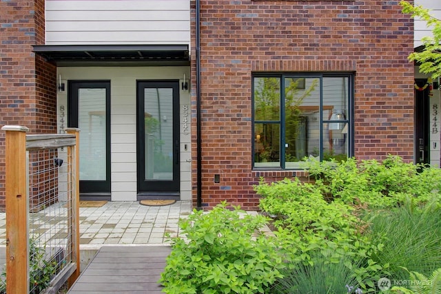 doorway to property featuring brick siding