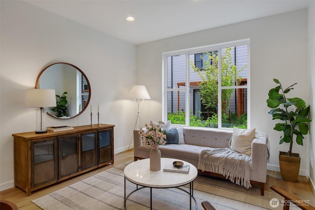 living area featuring light wood-type flooring, baseboards, and recessed lighting