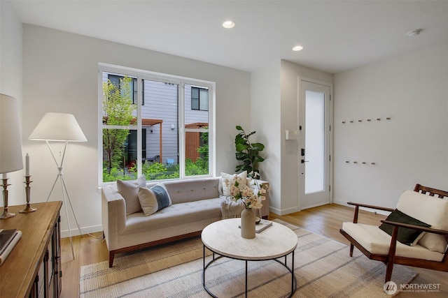living area featuring light wood finished floors, baseboards, and recessed lighting