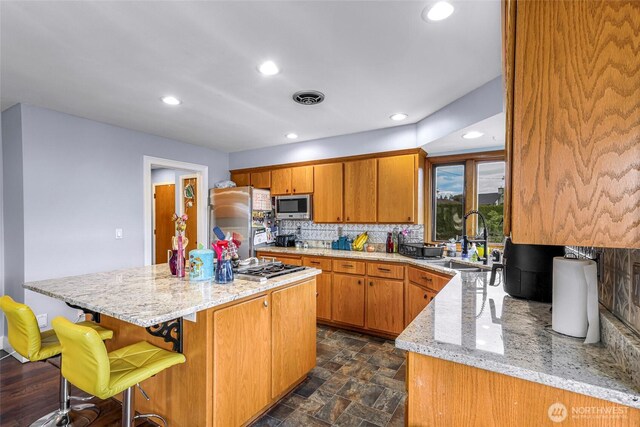 801 Bender Pl, Lynden, WA 98264 - kitchen with appliances with stainless steel finishes, a sink, recessed lighting, a kitchen island, and light stone countertops