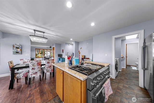 801 Bender Pl, Lynden, WA 98264 - kitchen featuring stainless steel appliances, baseboards, washing machine and dryer, a kitchen island, and light stone countertops