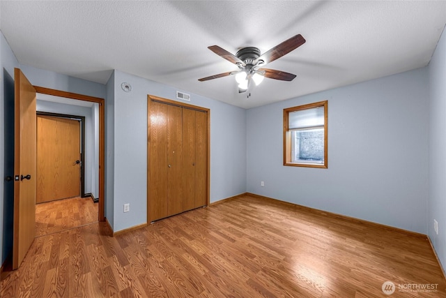 801 Bender Pl, Lynden, WA 98264 - unfurnished bedroom with a closet, wood finished floors, baseboards, ceiling fan, and a textured ceiling