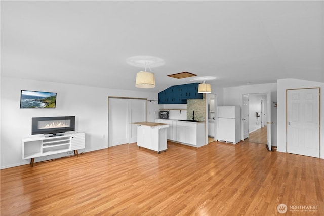 9320 96th St NE, Arlington, WA 98223 - unfurnished living room with a sink, baseboards, and light wood finished floors