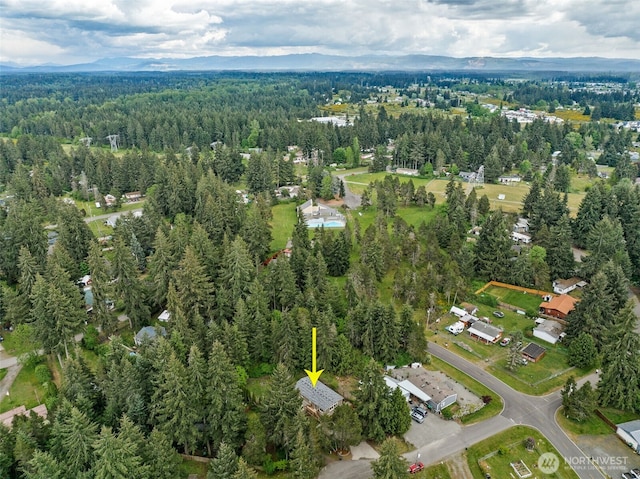 aerial view of property and surrounding area featuring a forest