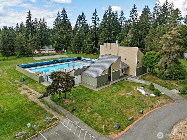 view of pool with a lawn and a covered pool