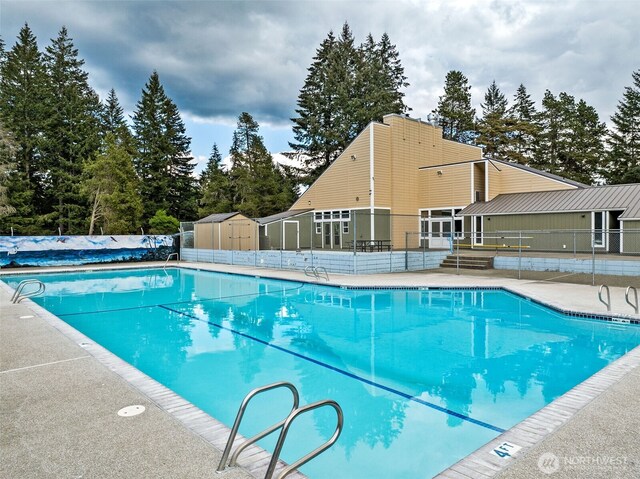 community pool featuring fence and a patio