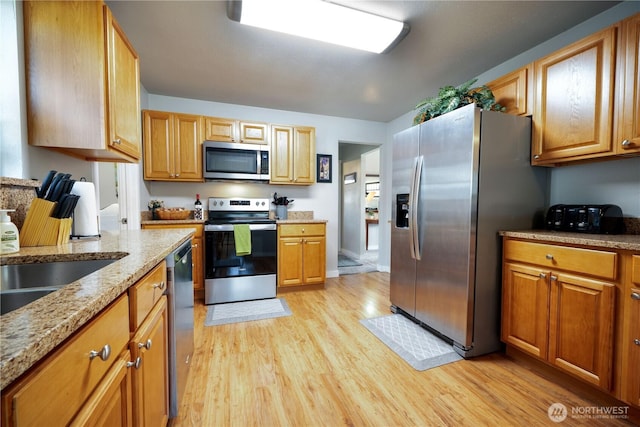 213 N Division, Elma, WA 98541 - kitchen featuring stainless steel appliances, light wood-style floors, light stone countertops, and brown cabinets