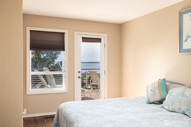 987 NW Camano Dr, Camano Island, WA 98282 - bedroom with access to outside, dark wood-style flooring, multiple windows, and baseboards