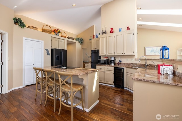 987 NW Camano Dr, Camano Island, WA 98282 - kitchen featuring wine cooler, black appliances, a sink, high vaulted ceiling, and dark wood-style floors