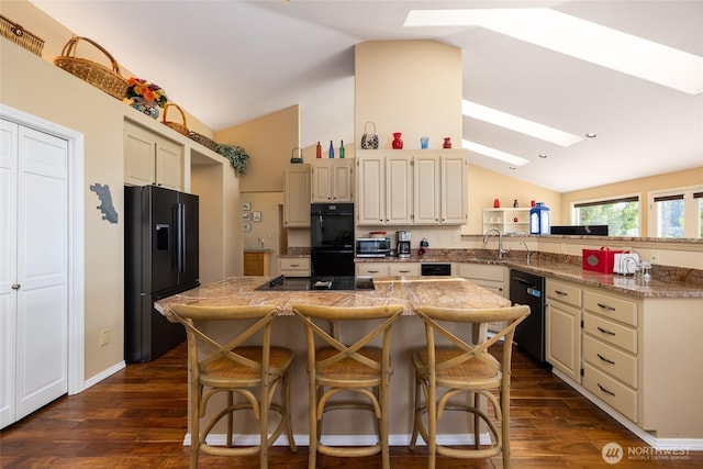 987 NW Camano Dr, Camano Island, WA 98282 - kitchen with black appliances, lofted ceiling, a skylight, a peninsula, and a sink