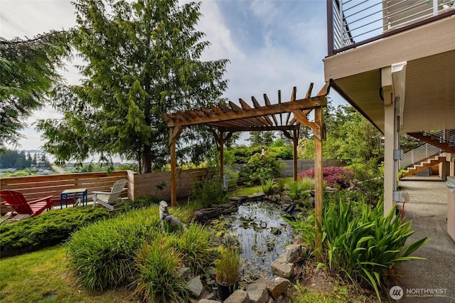 987 NW Camano Dr, Camano Island, WA 98282 - view of yard with fence, a pergola, a garden pond, and stairway