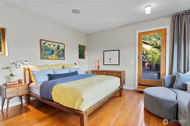 bedroom featuring light wood-style flooring, baseboards, and access to exterior
