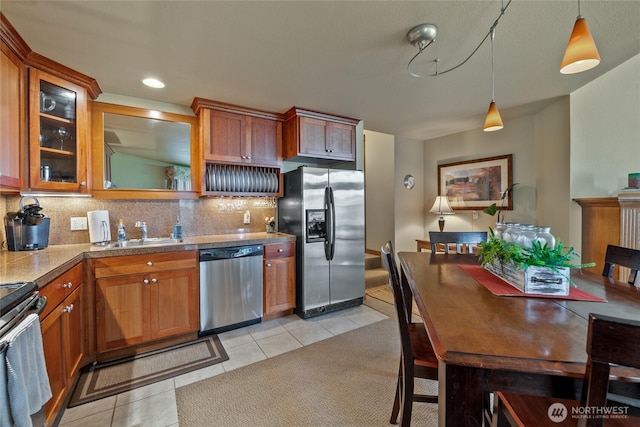 7806 Birch Bay Dr Unit 515, Blaine, WA 98230 - kitchen featuring appliances with stainless steel finishes, a sink, tasteful backsplash, light tile patterned floors, and brown cabinets