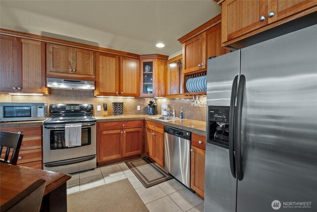 7806 Birch Bay Dr Unit 515, Blaine, WA 98230 - kitchen with stainless steel appliances, under cabinet range hood, light tile patterned floors, brown cabinetry, and recessed lighting