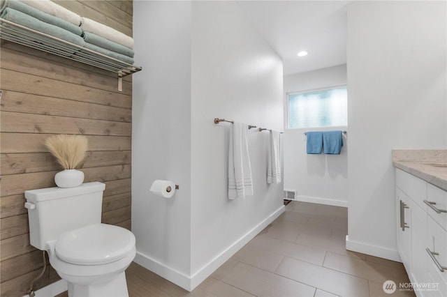 bathroom featuring toilet, baseboards, vanity, tile patterned floors, and recessed lighting