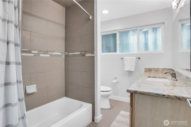 bathroom featuring toilet, baseboards, vanity, and shower / tub combo