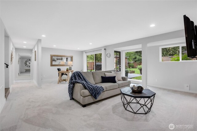 living area featuring light carpet, recessed lighting, and baseboards
