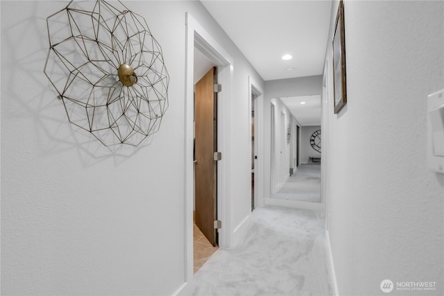 hallway featuring light carpet, baseboards, and recessed lighting
