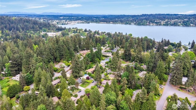 drone / aerial view of a heavily wooded area and a nearby body of water