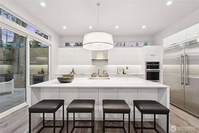 kitchen with appliances with stainless steel finishes, modern cabinets, white cabinetry, backsplash, and recessed lighting
