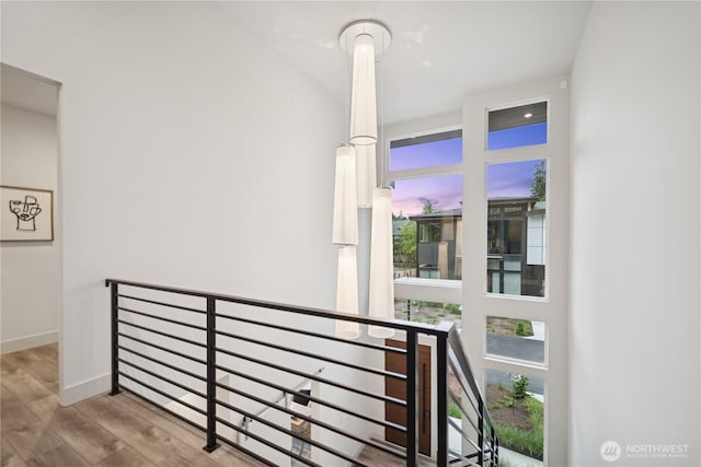 staircase featuring wood finished floors and baseboards