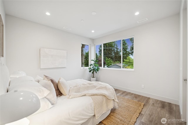 bedroom featuring wood finished floors, baseboards, and recessed lighting