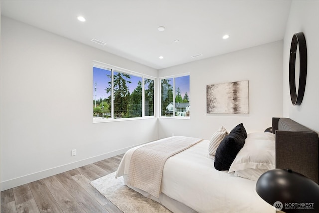 bedroom with wood finished floors, recessed lighting, and baseboards