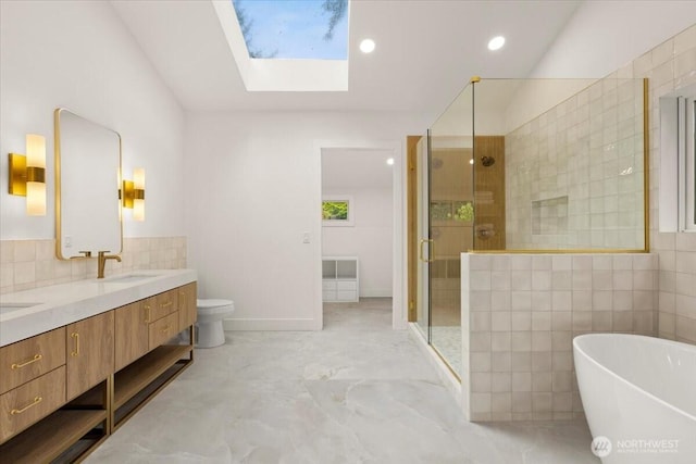 12914 43rd Ave Court NW, Gig Harbor, WA 98332 - bathroom with a skylight, a stall shower, a freestanding bath, double vanity, and tile walls