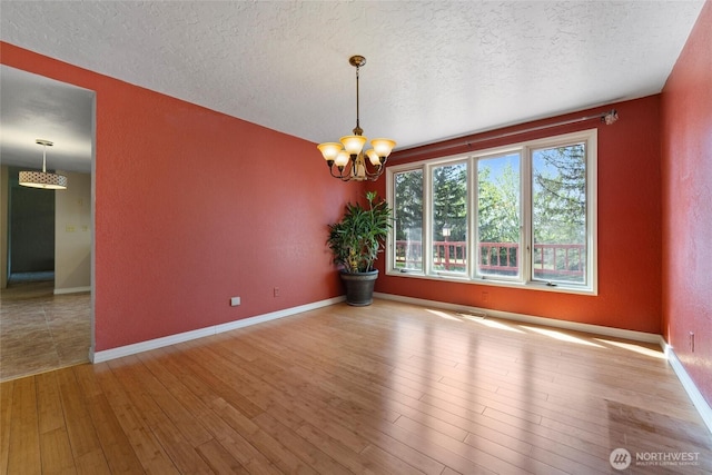 5207 NW Painted Hills Rd, Ephrata, WA 98823 - unfurnished dining area featuring a textured ceiling, wood finished floors, a chandelier, and baseboards