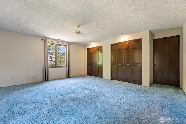 5207 NW Painted Hills Rd, Ephrata, WA 98823 - unfurnished bedroom featuring two closets, carpet, and a textured ceiling