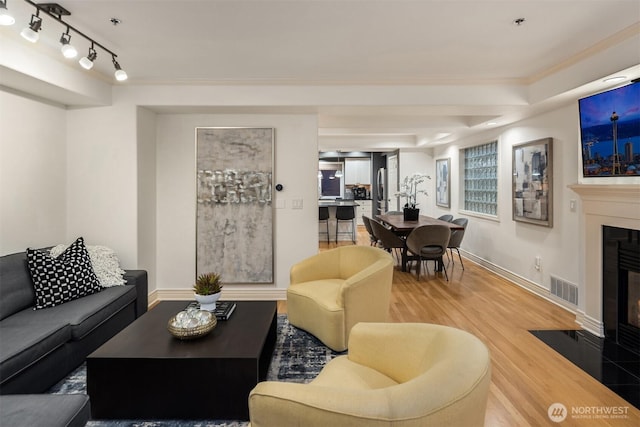 1416 6th Ave N, Seattle, WA 98109 - living room with a fireplace with flush hearth, wood finished floors, ornamental molding, and baseboards