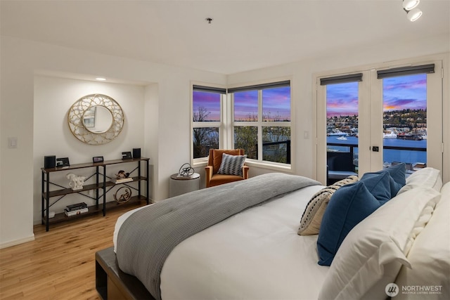 1416 6th Ave N, Seattle, WA 98109 - bedroom featuring access to outside, light wood-style flooring, a water view, and baseboards