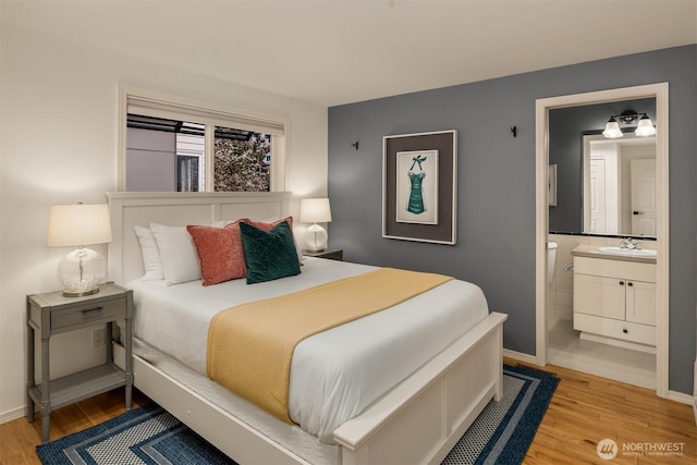 1416 6th Ave N, Seattle, WA 98109 - bedroom with wood finished floors, a sink, ensuite bathroom, and baseboards