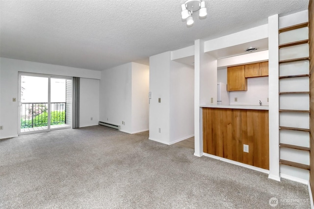 14650 NE 32nd St Unit A-13, Bellevue, WA 98007 - unfurnished living room featuring baseboard heating, wet bar, carpet flooring, a textured ceiling, and baseboards