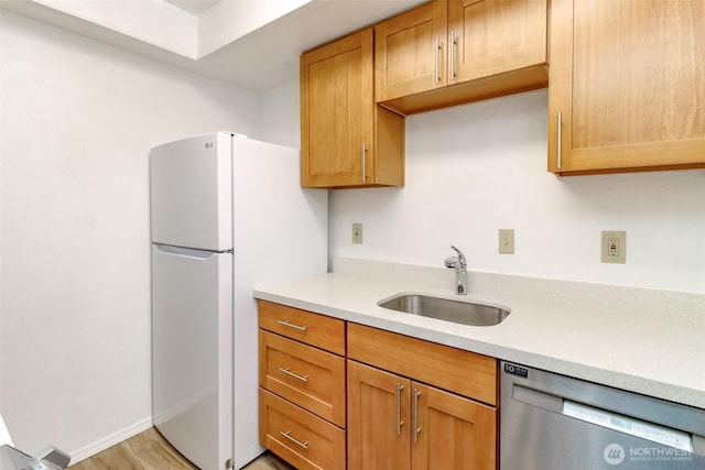 14650 NE 32nd St Unit A-13, Bellevue, WA 98007 - kitchen featuring stainless steel dishwasher, a sink, light countertops, and freestanding refrigerator