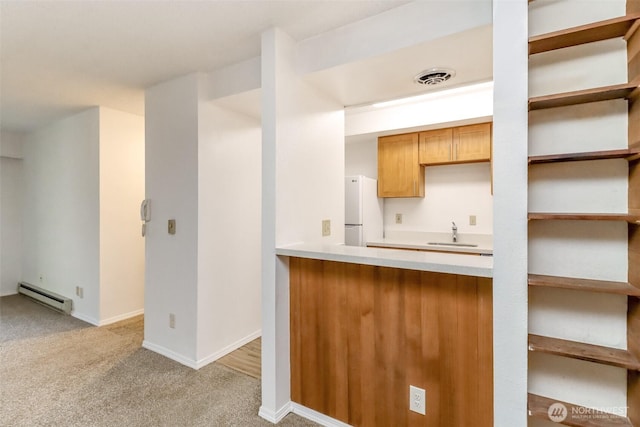 14650 NE 32nd St Unit A-13, Bellevue, WA 98007 - kitchen featuring a baseboard heating unit, freestanding refrigerator, a sink, light colored carpet, and light countertops