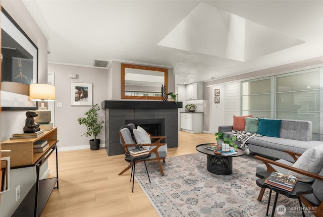 18906 32nd Ave NE, Lake Forest Park, WA 98155 - living room featuring baseboards, light wood-style floors, ornamental molding, and a fireplace