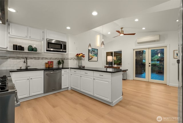 18906 32nd Ave NE, Lake Forest Park, WA 98155 - kitchen with appliances with stainless steel finishes, a sink, a peninsula, dark countertops, and light wood-type flooring