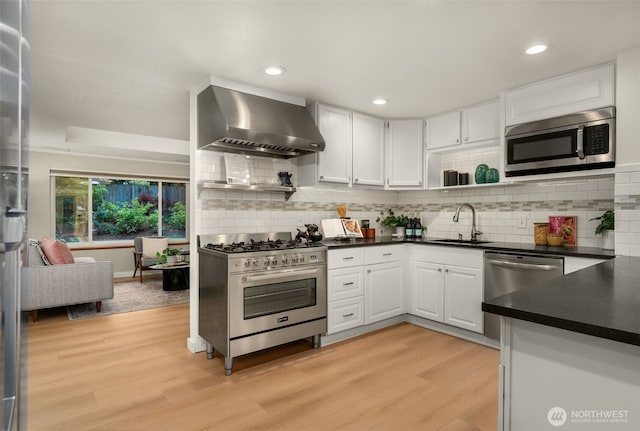 18906 32nd Ave NE, Lake Forest Park, WA 98155 - kitchen featuring wall chimney exhaust hood, stainless steel appliances, a sink, dark countertops, and recessed lighting