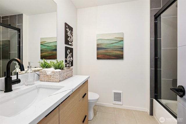 bathroom with tile patterned floors, vanity, baseboards, toilet, and enclosed tub / shower combo