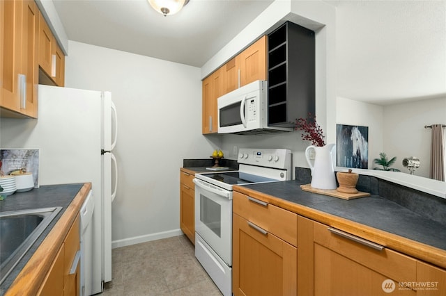 12044 96th Ave NE Unit 211, Kirkland, WA 98034 - kitchen featuring white appliances, dark countertops, a sink, and baseboards