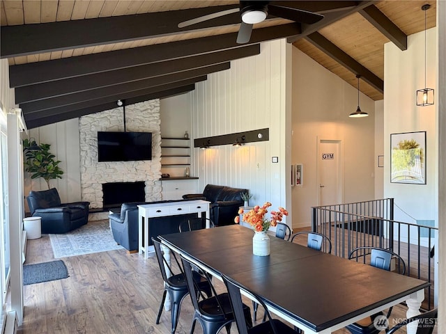 12513 NE 130th Way Unit C204, Kirkland, WA 98034 - dining area featuring wood ceiling with exposed beams, ceiling fan, wood finished floors, high vaulted ceiling, and a stone fireplace