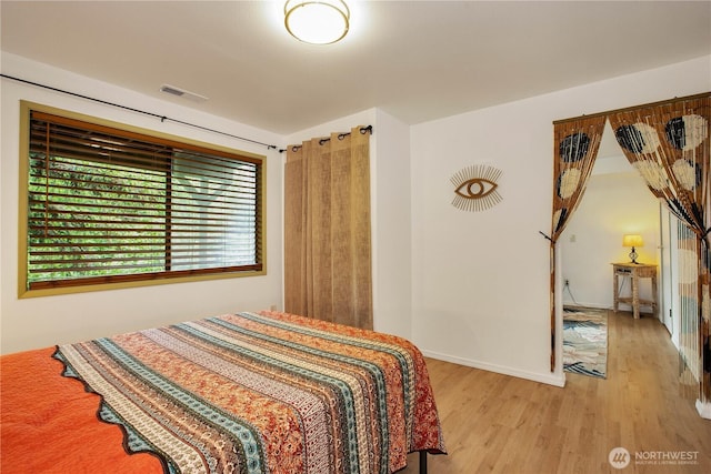 bedroom with wood finished floors and baseboards