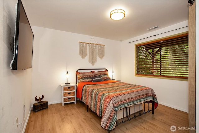 bedroom with wood finished floors and baseboards