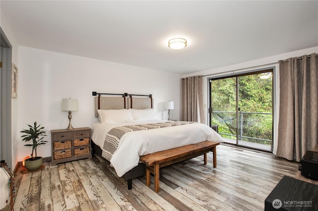 bedroom with access to outside and wood finished floors