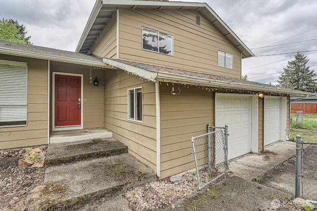 21502 38th Ave E, Spanaway, WA 98387 - doorway to property with fence, roof with shingles, and a garage