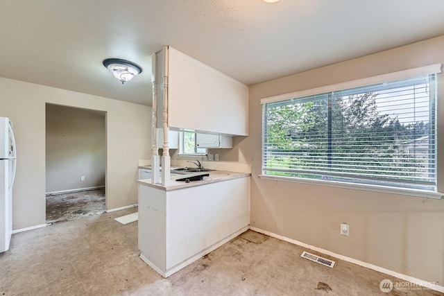 21502 38th Ave E, Spanaway, WA 98387 - kitchen with white cabinets, light countertops, a sink, and freestanding refrigerator