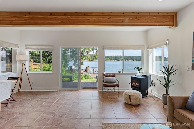 7610 E Grapeview Loop Rd, Allyn, WA 98524 - sunroom / solarium featuring a wood stove, healthy amount of natural light, and a water view