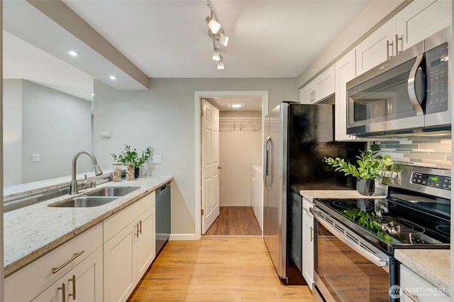 12724 NE 144th St Unit E-104, Kirkland, WA 98034 - kitchen featuring stainless steel appliances, a sink, light wood finished floors, white cabinets, and light stone countertops
